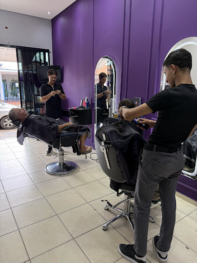 Barbeiro atendendo um cliente dentro da Barbearia Terrier